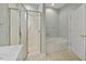 Clean bathroom with a glass-enclosed shower, soaking tub, and neutral tile flooring at 28 W Madison, Pittsboro, NC 27312