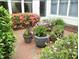 Brick patio area with various potted plants and flowers, offering a cozy outdoor space at 28 W Madison, Pittsboro, NC 27312
