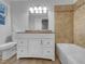 Bathroom showcasing a vanity with drawers, a framed mirror with a decorative light fixture, and a bathtub at 2836 Thurrock Dr, Apex, NC 27539