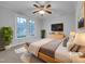 Cozy bedroom featuring large windows, neutral colors, and a ceiling fan with light fixture at 2836 Thurrock Dr, Apex, NC 27539