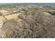 Aerial view of a expansive property with a pond and surrounded by a dense forest at 4051 Silk Hope Gum Springs Rd, Pittsboro, NC 27312