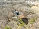Aerial view of the house with a pool, pond and surrounded by mature trees at 4051 Silk Hope Gum Springs Rd, Pittsboro, NC 27312
