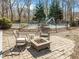 Cozy backyard patio with stone pavers, a fire pit, and wrought iron chairs for outdoor relaxing at 4051 Silk Hope Gum Springs Rd, Pittsboro, NC 27312