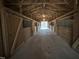 Interior shot of a barn featuring horse stalls and a concrete floor at 4051 Silk Hope Gum Springs Rd, Pittsboro, NC 27312