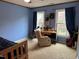 Blue bedroom featuring a ceiling fan, tan carpet, and a desk by the windows at 4051 Silk Hope Gum Springs Rd, Pittsboro, NC 27312