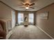 Bedroom featuring a ceiling fan, carpet, and two windows with white curtains at 4051 Silk Hope Gum Springs Rd, Pittsboro, NC 27312