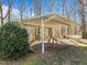 Carport with a gray corrugated metal roof and support posts next to a decorative bush in a wooded area at 4051 Silk Hope Gum Springs Rd, Pittsboro, NC 27312