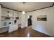 Open dining room with hardwood floors, built-in shelving, and a view into the kitchen at 4051 Silk Hope Gum Springs Rd, Pittsboro, NC 27312