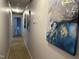 Hallway with paintings leading to a carpeted bedroom with visible natural light at 4051 Silk Hope Gum Springs Rd, Pittsboro, NC 27312