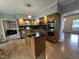 Well-lit kitchen with oak cabinets, stainless steel appliances, and a view into the living area at 4051 Silk Hope Gum Springs Rd, Pittsboro, NC 27312