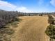 Expansive field under a clear blue sky, showcasing the property's potential for development or agricultural use at 4051 Silk Hope Gum Springs Rd, Pittsboro, NC 27312