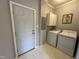 Functional laundry room features a white washer and dryer, storage cabinets, and access to the exterior at 4051 Silk Hope Gum Springs Rd, Pittsboro, NC 27312