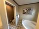 Bathroom featuring a corner tub, toilet and tiled floors at 4051 Silk Hope Gum Springs Rd, Pittsboro, NC 27312