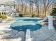 Outdoor pool with slide and diving board, featuring a pool cover and concrete surround at 4051 Silk Hope Gum Springs Rd, Pittsboro, NC 27312