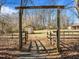 Wooden gate leads to shed with a door, on a large piece of property surrounded by trees at 4051 Silk Hope Gum Springs Rd, Pittsboro, NC 27312