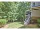 Backyard showcasing a raised deck with stairs and a screened-in porch, surrounded by lush greenery and mature trees at 407 Crickentree Dr, Cary, NC 27518