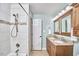 Bright bathroom featuring double sinks, granite countertops, and a tiled shower at 407 Crickentree Dr, Cary, NC 27518