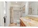 Bathroom featuring tiled shower and bath, marble vanity and flooring, and updated fixtures at 407 Crickentree Dr, Cary, NC 27518