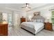 A light and airy bedroom with light grey plank floors, white trim, and a ceiling fan at 407 Crickentree Dr, Cary, NC 27518