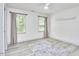 Spacious bedroom featuring laminate flooring, two windows, and neutral decor at 407 Crickentree Dr, Cary, NC 27518
