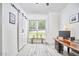 Bright bonus room with barn door, plank floors, large window, and custom wood desk and monitor at 407 Crickentree Dr, Cary, NC 27518