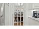 View of the dining room through glass paned doors featuring an elegant chandelier and hardwood flooring at 407 Crickentree Dr, Cary, NC 27518