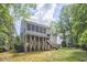 Back exterior showcasing a raised deck with stairs and a screened-in porch, surrounded by mature trees at 407 Crickentree Dr, Cary, NC 27518