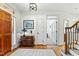 Foyer features hardwood floors, staircase, wooden door, white walls, area rug, dresser, and view to hallway at 407 Crickentree Dr, Cary, NC 27518