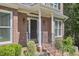Close up on the front entry, brick facade, small bushes, black door with number, and white pillars at 407 Crickentree Dr, Cary, NC 27518