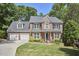 Charming two-story brick home with manicured front yard and a driveway leading to an attached two-car garage at 407 Crickentree Dr, Cary, NC 27518