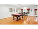 Hardwood floors highlight a pool table, complemented by natural light from the windows at 407 Crickentree Dr, Cary, NC 27518