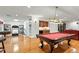 Spacious game room with a pool table, wet bar, exercise equipment, and hardwood floors at 407 Crickentree Dr, Cary, NC 27518