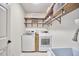 Functional laundry room with washer, dryer, shelving, and a utility sink at 407 Crickentree Dr, Cary, NC 27518