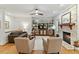 Bright living room with a stone fireplace, hardwood floors, and built-in shelving at 407 Crickentree Dr, Cary, NC 27518