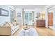 Living room showcasing hardwood floors, white walls, large windows, sofa, side tables, and wooden dresser at 407 Crickentree Dr, Cary, NC 27518