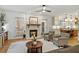 Bright and airy living room featuring a stone fireplace, hardwood floors, and access to the kitchen and dining area at 407 Crickentree Dr, Cary, NC 27518
