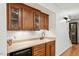 Wet bar features wood cabinets, granite countertops, a sink, and a beverage cooler at 407 Crickentree Dr, Cary, NC 27518