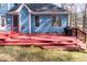 View of the wooden back deck of a blue house; features stairs and a grill at 4325 New Hope Springs Dr, Hillsborough, NC 27278