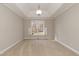Bright, carpeted bedroom with tray ceiling, crown moulding, and a view to the outside at 4325 New Hope Springs Dr, Hillsborough, NC 27278