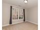 Cozy bedroom with neutral walls, carpet, and a window offering a view of the outdoors at 4325 New Hope Springs Dr, Hillsborough, NC 27278