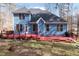 Rear exterior view featuring a two story home with an expansive, red deck for entertaining guests at 4325 New Hope Springs Dr, Hillsborough, NC 27278