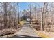 Secluded home nestled in a wooded area with a long driveway leading to a two-car garage at 4325 New Hope Springs Dr, Hillsborough, NC 27278