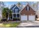 Two-story home with blue siding and brick accents, featuring a two-car garage and landscaped front yard at 4325 New Hope Springs Dr, Hillsborough, NC 27278