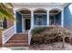 Welcoming front porch with brick steps, white railings, and a decorative front door at 4325 New Hope Springs Dr, Hillsborough, NC 27278
