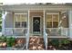 Inviting front porch with white railings, neutral siding, and charming floral wreath on the black front door at 4713 Malone Ct, Raleigh, NC 27616