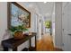 Bright hallway featuring hardwood floors, white walls, and a decorative painting on the left at 4713 Malone Ct, Raleigh, NC 27616