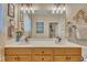 Well-lit bathroom features a double sink vanity with modern fixtures, a large mirror and soft decor at 505 Wild Goose Ln, Creedmoor, NC 27522