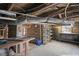 Basement with exposed piping, work bench, storage shelves, and concrete walls and floor at 512 S Mebane St, Burlington, NC 27215