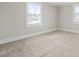 An empty bedroom with neutral carpet features two windows for natural light at 512 S Mebane St, Burlington, NC 27215