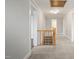 Bright hallway with a wooden railing staircase and neutral carpet at 512 S Mebane St, Burlington, NC 27215
